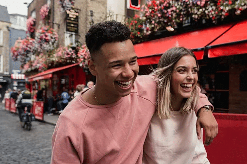 A young couple hand in hand running out of public house in Dublin (Credits: Getty Images)